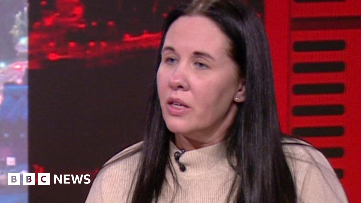 Sharon with long dark hair wearing a cream jumper in the BBC North West Tonight studio.