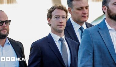 Adam Mosseri, head of Instagram, speaking before a Senate committee in 2021 wearing rounded black-rimmed eyeglasses and a simple dark blue suit and tie.
