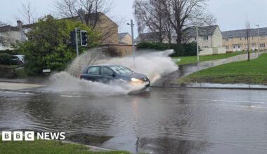 A car drives through a flooded road in East Lothian, Scotland