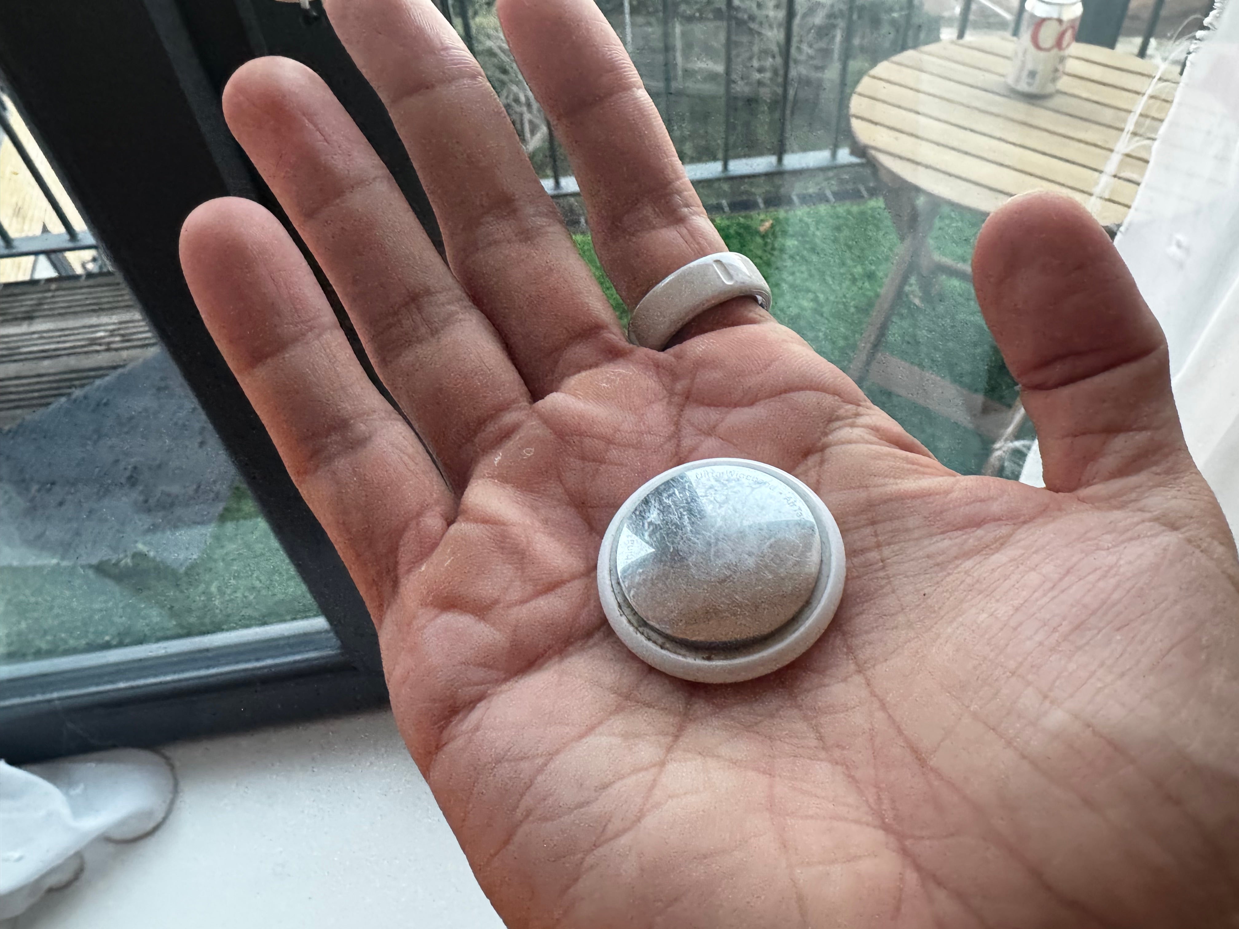 An Apple AirTag, which is only around 3cm wide and just 11g