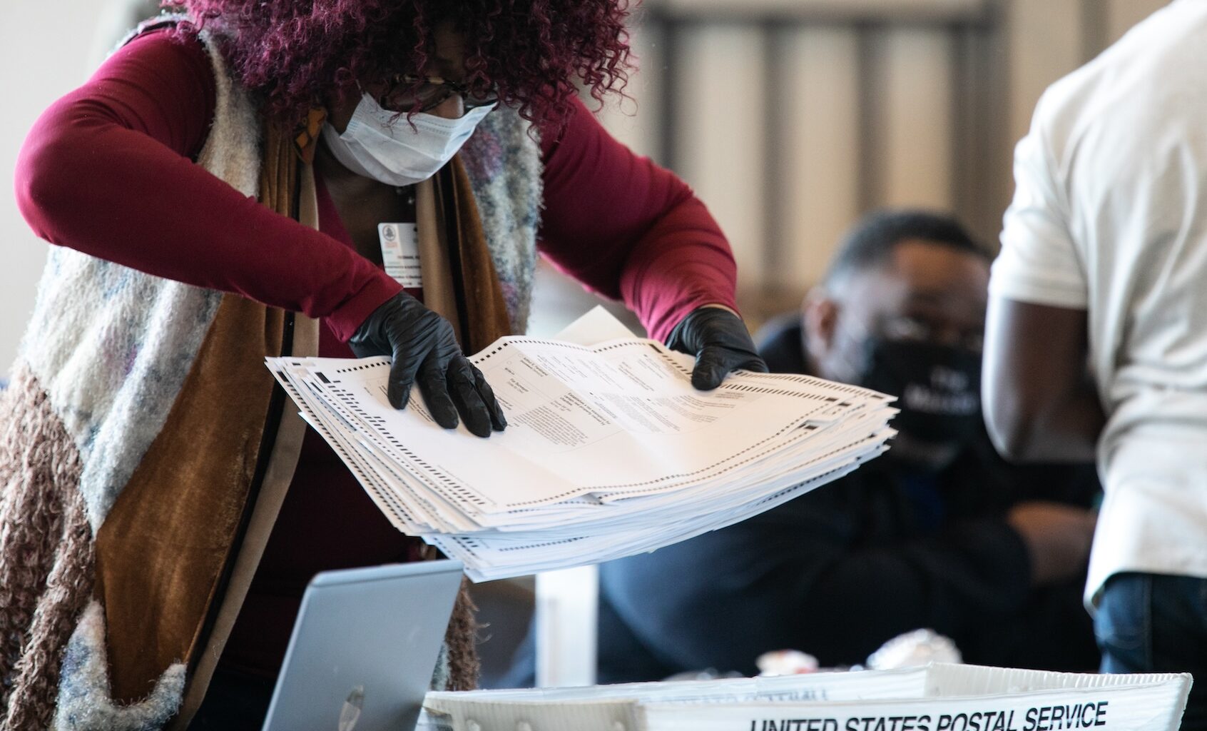 A Fulton county worker moves a stack of absentee ballots at State Farm Arena on November 6, 2020 in Atlanta, Georgia. The 2020 presidential race between incumbent U.S. President Donald Trump and Democratic nominee Joe Biden is still too close to call with outstanding ballots in a number of states including Georgia. (Photo by Jessica McGowan/Getty Images)