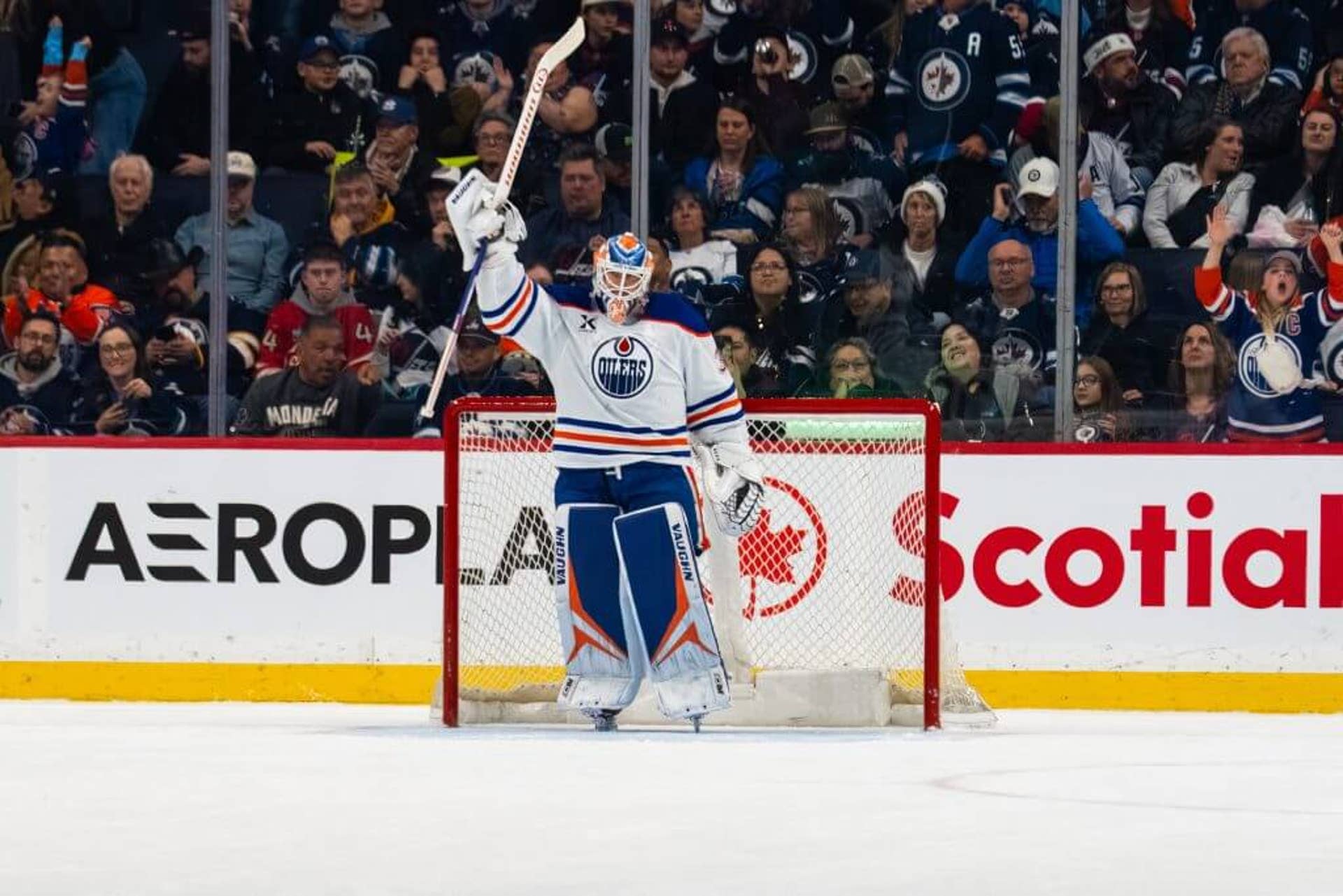 Calvin Pickard raises his stick into the air from the Oilers' net.