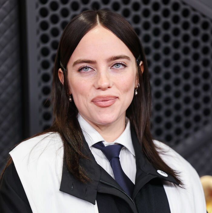 Billie Eilish at an event wearing a black and white outfit, her Grammys rant sparking a firestorm over her lifestyle.