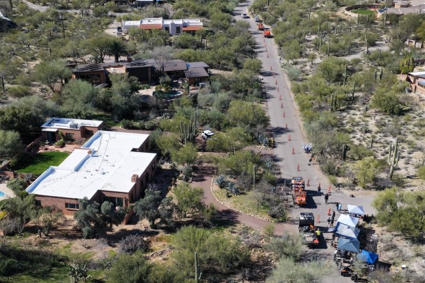 In an aerial view, road crews set up signs and barricades in front of Nancy Guthrie's residence to turn the two-lane road into a one-lane road on February 21, 2026, in Tucson, Arizona. The road was turned into a one-way due to heavy traffic in the area. Law enforcement officials continue to search for Nancy Guthrie, the 84-year-old mother of U.S. journalist and television host Savannah Guthrie, after she went missing from her home on the morning of February 1st. An anonymous donor contributed $100,000 to the total reward offered in the Nancy Guthrie case, bringing it to over $200,000. (Photo by Joe Raedle/Getty Images)