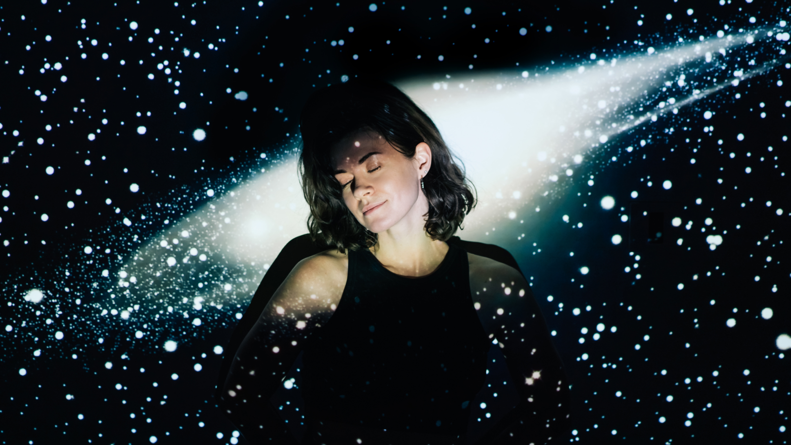 Image projection of space on a young beautiful woman with short curly hair.