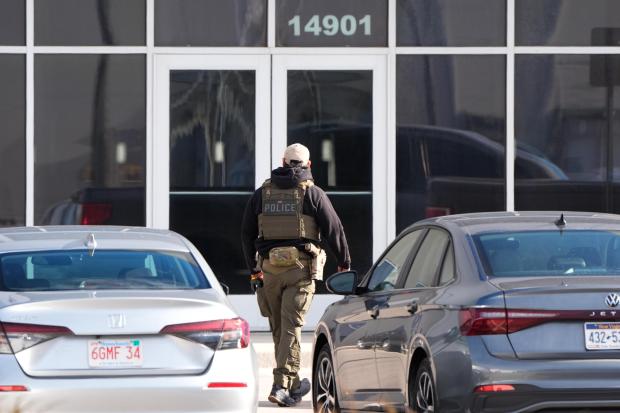 An ICE agent stands outside a warehouse as federal officials tour the facility to consider repurposing it as an ICE detention facility, Thursday, Jan. 15, 2026, in Kansas City, Mo. (AP Photo/Charlie Riedel)