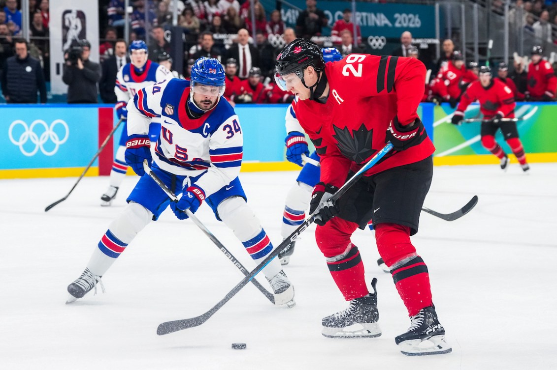 Nathan MacKinnon plays the puck against Auston Matthews