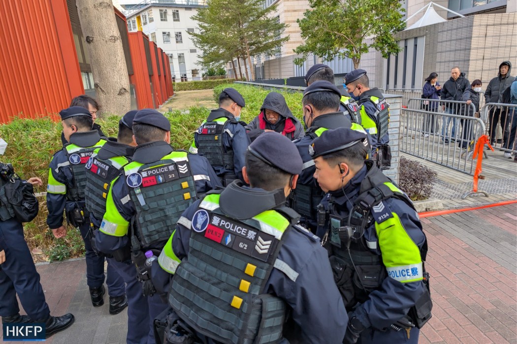 Activist Tsang Kin-shing, known as "the Bull," is searched by police outside the West Kowloon Law Courts on February 9, 2026, ahead of the sentencing of pro-democracy media tycoon Jimmy Lai. Photo: Kyle Lam/HKFP.