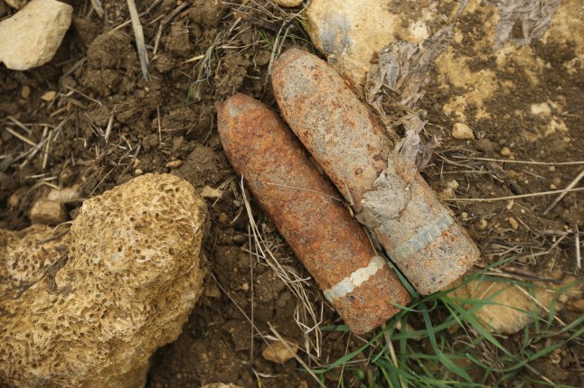 VERDUN, FRANCE - AUGUST 26: Unexploded artillery shell from World War I found by a local farmer lie in a field at Champneuville prior to the arrival of mine-clearing specialists on August 26, 2014 near Verdun, France. Specialists Guy Momper and his colleague Raoul Weber are among a handful of men kown in French as 