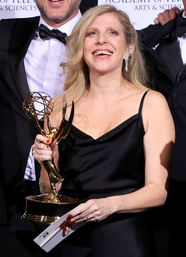 Creator and Executive Producer Dana Eden poses backstage with cast and crew members after winning an Emmy for 