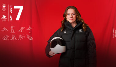 Skeleton athlete Hallie Clarke, holding helmet and smiling for photo.