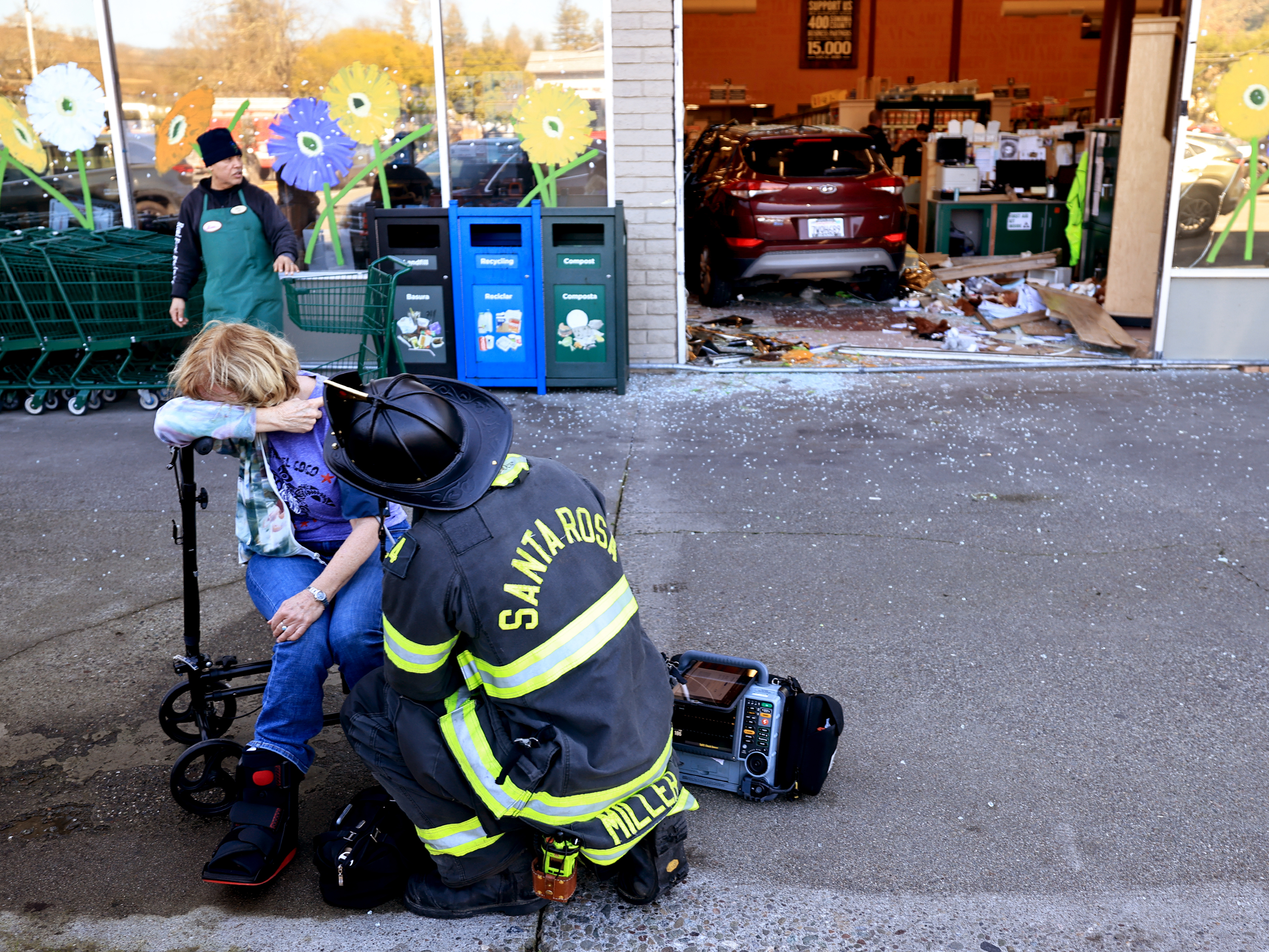 A woman is comforted in front of Oliverâs Market on...