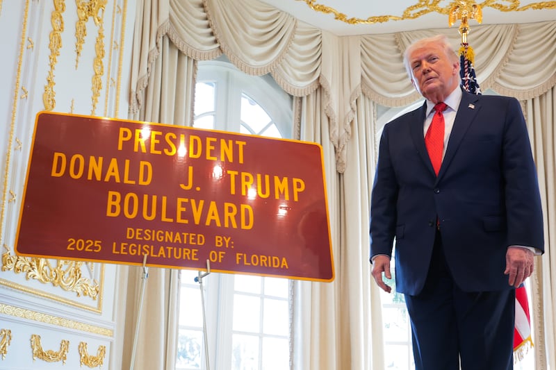 President Donald Trump poses for a photo with a sign that reads "President Donald J. Trump Boulevard" during a Road Dedication Ceremony at Mar-a-Lago on January 16, 2026 in Palm Beach, Florida. Florida State lawmakers approved the name change of a portion of Southern Boulevard to “President Donald J. Trump Boulevard.”