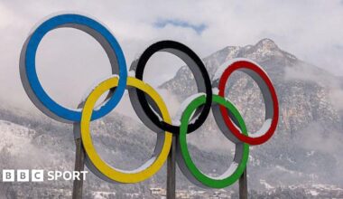 The Olympic rings with a snowy mountain in the background