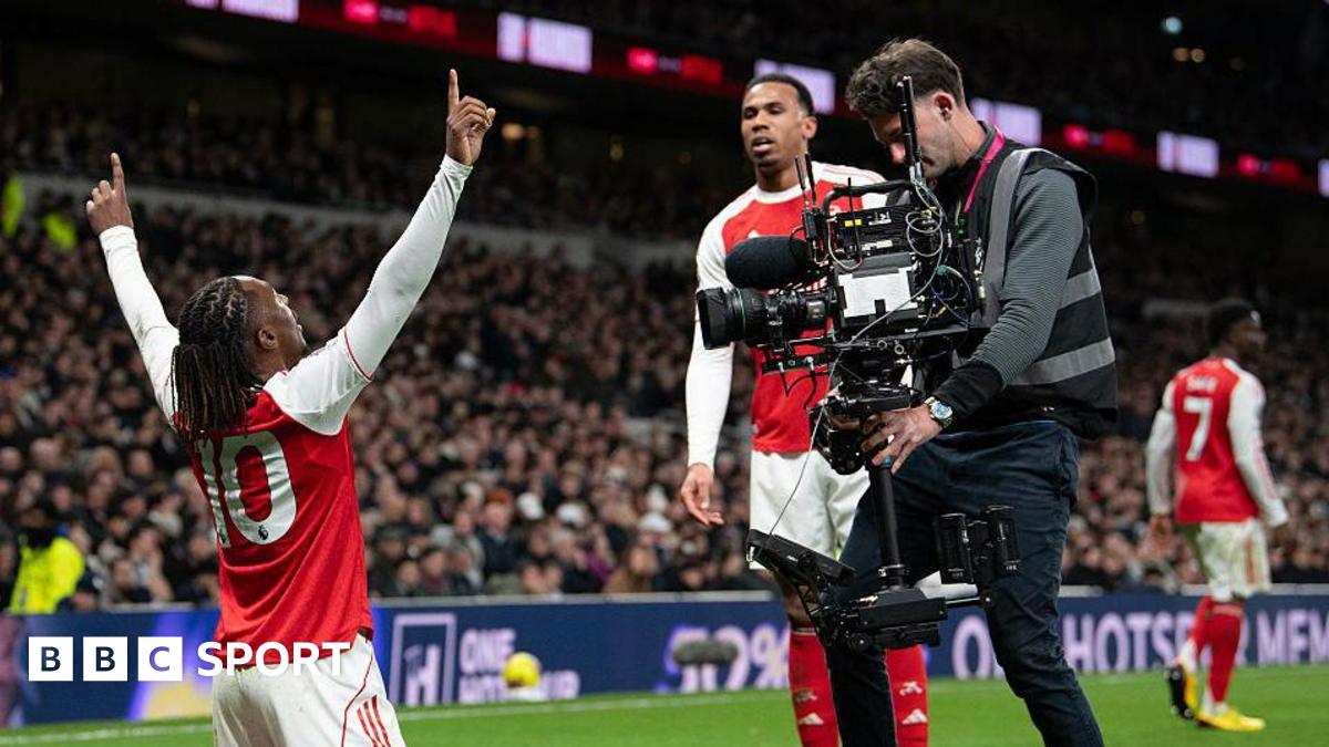 A cameraman films Arsenal's Eberechi Eze as he celebrates scoring a goal