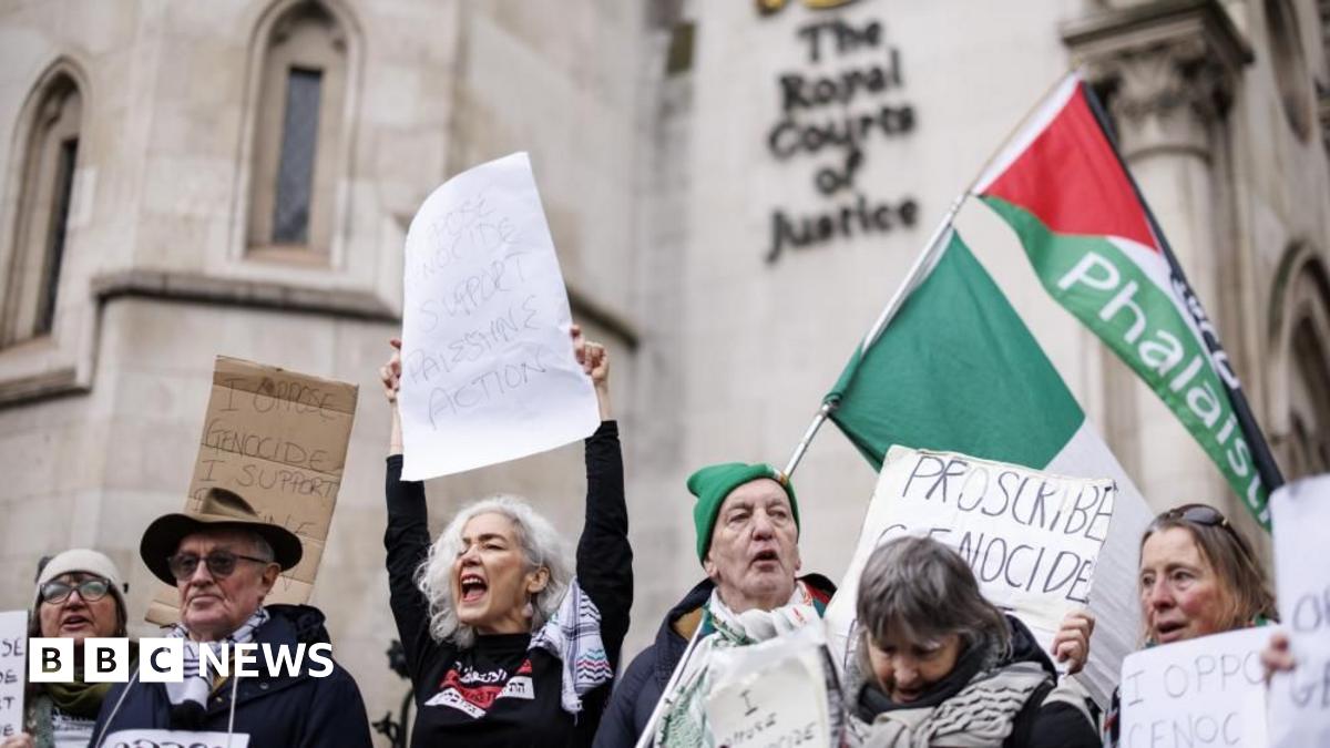 Several people hold placards and celebrate outside the court
