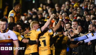 Castleford players come together with try scorer Tom Weaver to celebrate with fans behind the in-goal area