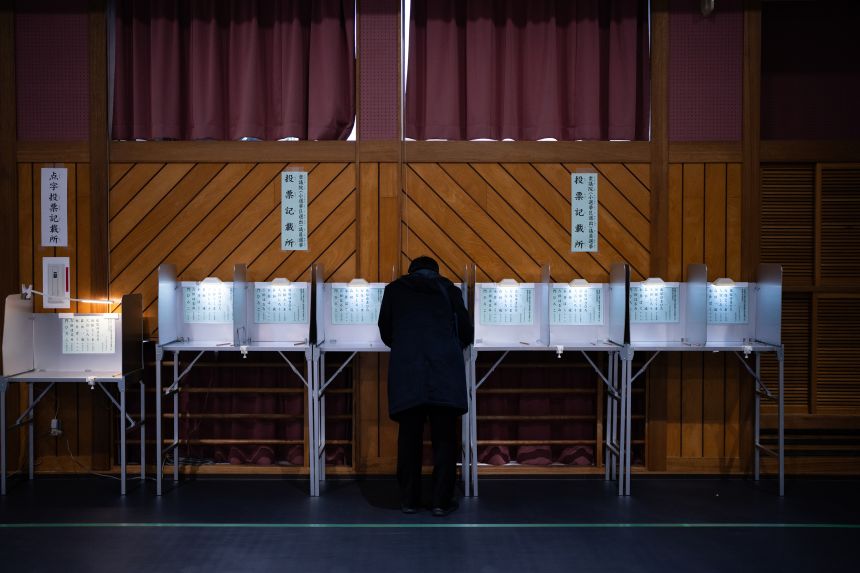 A voter fills a ballot in the lower house election at a polling station in Tokyo Sunday.