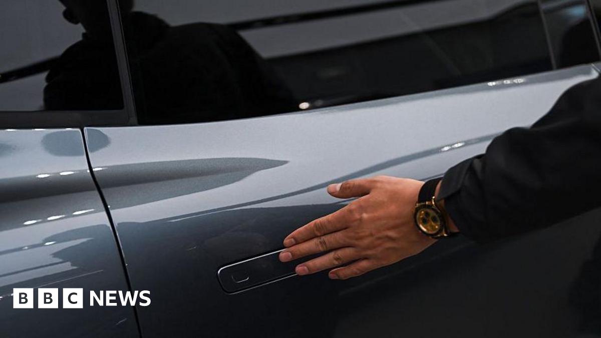 A man opens the door for a Zeekr X7 electric vehicle at a showroom in Beijing on 3 February, 2026