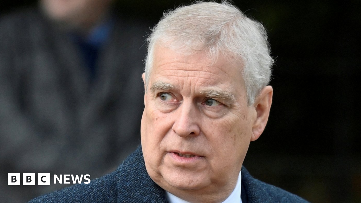 A head and shoulders image of a man with grey hair and brown eyes looking off to his right. He is wearing a blue herringbone jacket