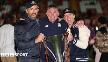 Ryan Reynolds, Phil Parkinson and Rob Mac pose with the National League trophy