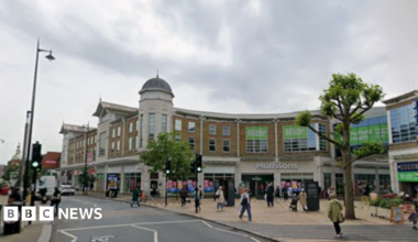 A Google image of Wimbledon Broadway - there are people shopping and cars driving along the road.