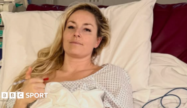 Lindsey Vonn, wearing a hospital gown, smiles