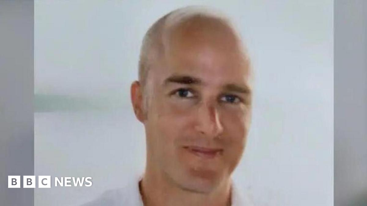 A head and shoulders shot of a bald man who is smiling.