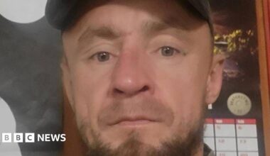 Piotr Pruszak has a light brown beard and wears a cap.