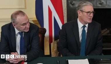Sir Chris Wormald looks sideways at Sir Keir Starmer at the cabinet table with a union jack behind them