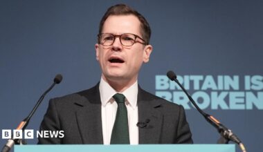 A row of red-brick houses with almost every window and door boarded up
