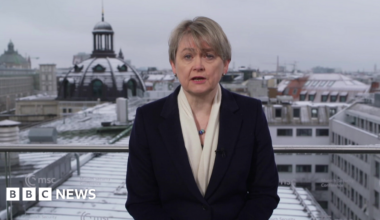 A portrait of late Russian opposition leader Alexei Navalny sits among floral tributes and a candle outside the Russian embassy in Berlin