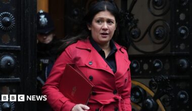 Lisa Nandy wearing a red coat and holding a red folder