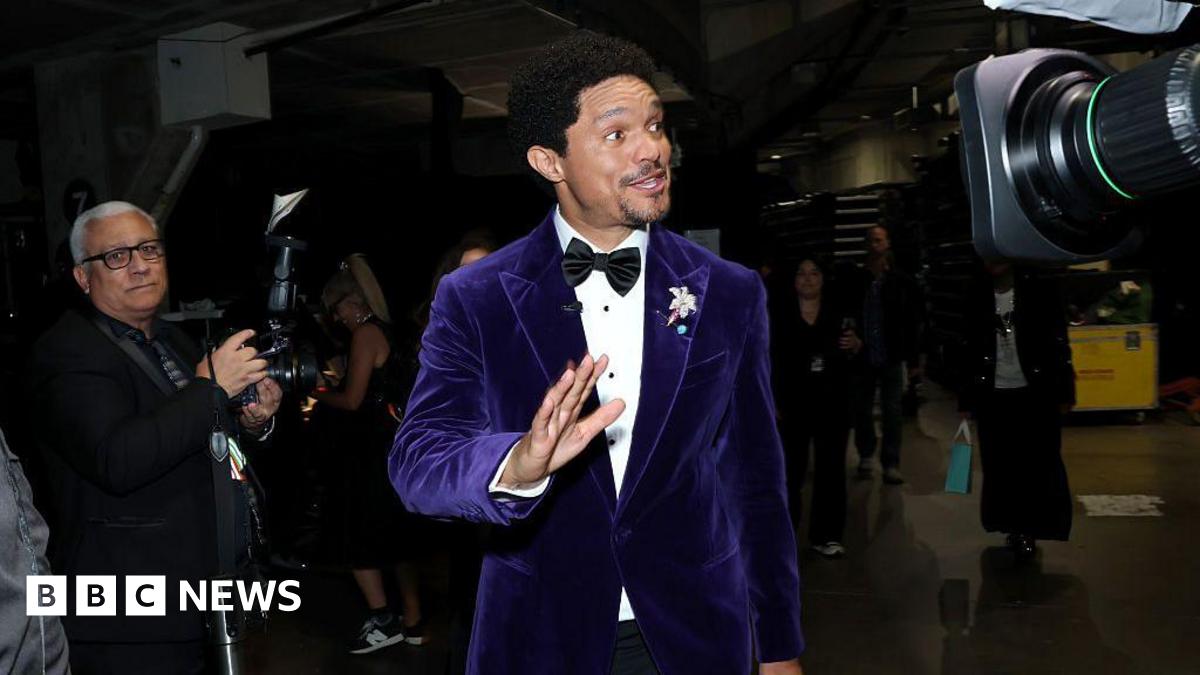 Trevor Noah wearing a purple suit at the Grammys.