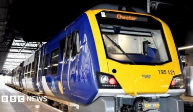 An image of a blue-and-yellow train standing at a platform. Chester is showing as the train's destination on a digital display above the driver's compartment.