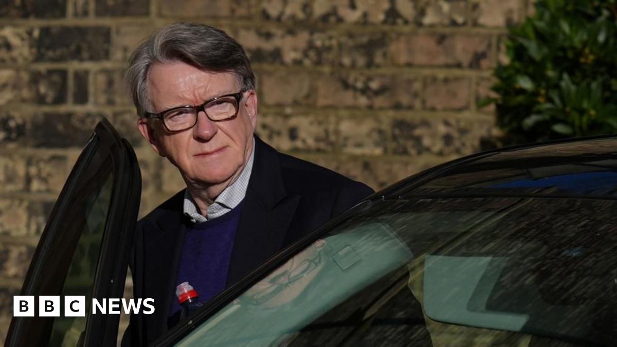 Lord Mandelson - wearing a dark jacket, light shirt and blue jumper - getting into a car