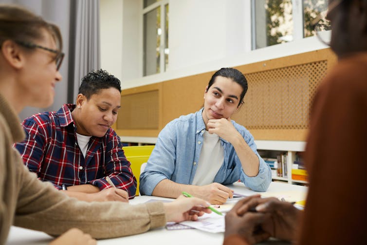 People sitting at desks in a classroom in discussion.