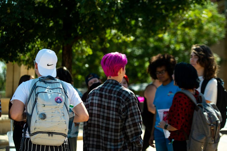 Young people in a crowd walking outdoors.