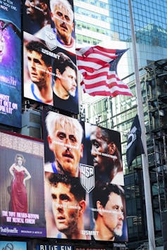 An American flag flies next to posters of sporting stars' faces.