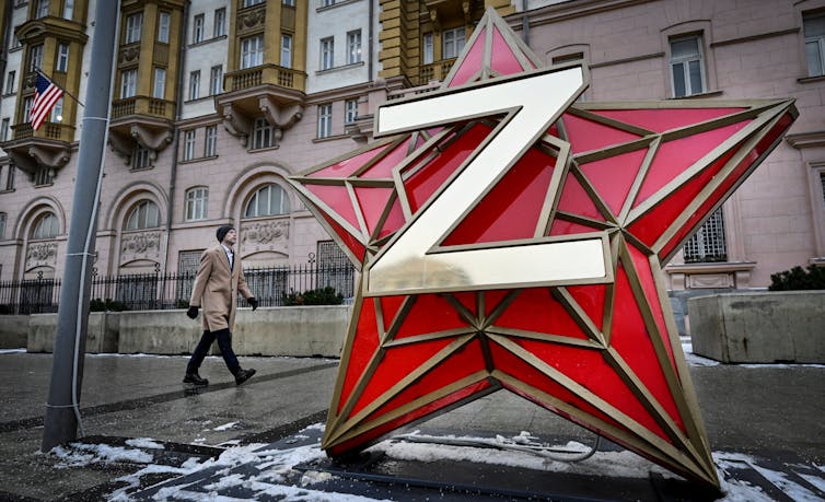 A giant star with a letter Z on it is in front of a building.