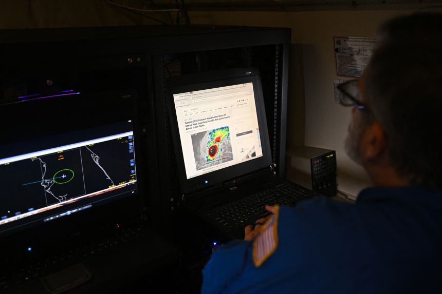 A crew member looks at a laptop inside a NOAA WP-3D Orion Hurricane Hunter research plane at the National Oceanic and Atmospheric Administration's (NOAA) Aircraft Operations Center in Lakeland, Florida, on May 6, 2025.