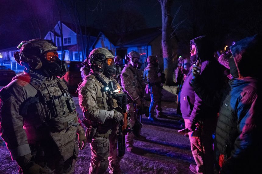Federal law enforcement officers face off with Minneapolis residents after an agent shot a man in the leg on January 15.