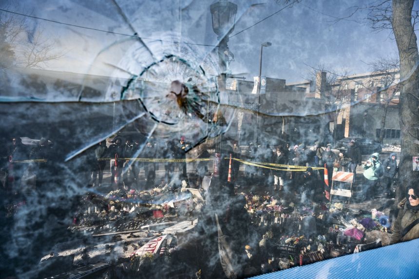Shattered glass from a bullet is seen in front of a makeshift memorial for Alex Pretti on January 26 in Minneapolis.