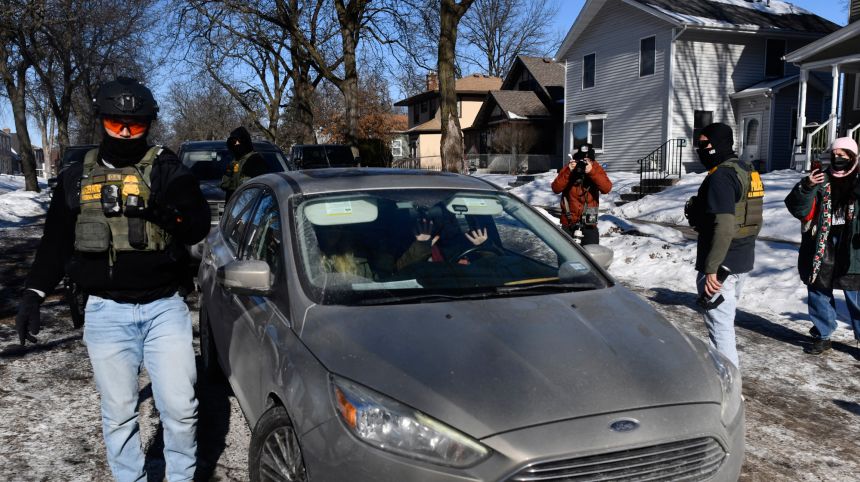 Federal immigration agents confront observers monitoring their activity in Minneapolis from inside their cars on January 29.