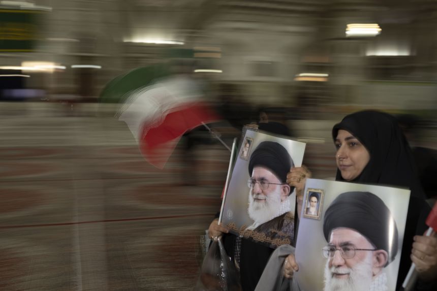 Two veiled Iranian women carry portraits of Iran's Supreme Leader, Ayatollah Ali Khamenei, during a ceremony marking the 47th anniversary of the victory of Iran's Islamic Revolution in Tehran in February, 2026.