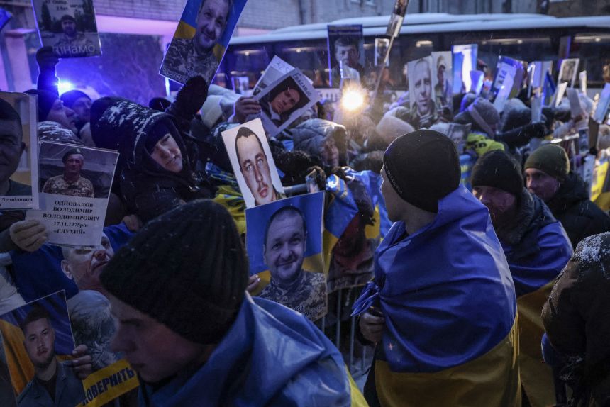Family members hold photos of their captured relatives as Ukrainian prisoners of war released from Russian captivity arrive home following a prisoner exchange between the two sides this week.