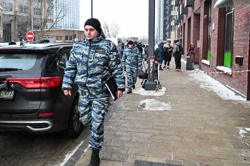 Police officers walk past a high-rise residential building, the scene of the shooting of Russian Lt. Gen. Vladimir Alekseyev, in Moscow on Friday.