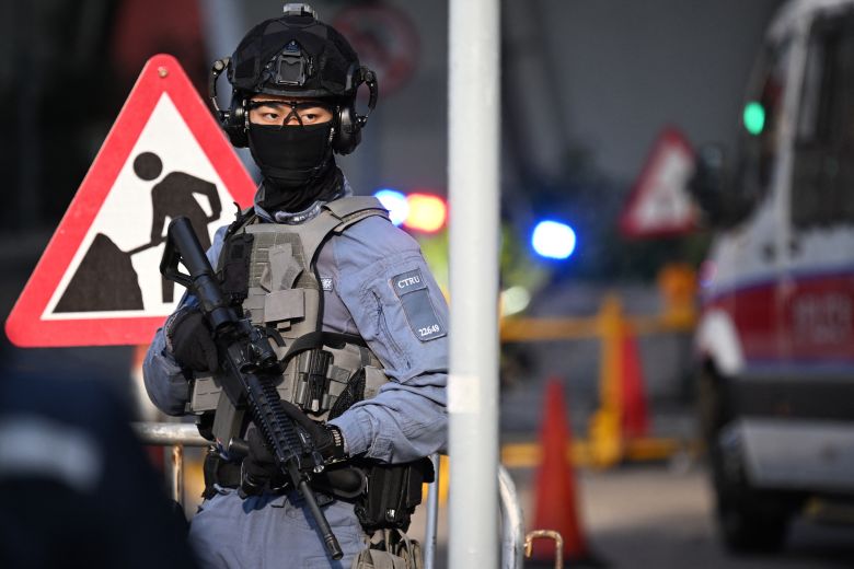 Armed police keep watch outside the West Kowloon Magistrates' court for the sentencing of convicted pro-democracy media tycoon Jimmy Lai in Hong Kong on February 9, 2026.