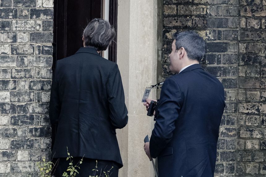 Two people believed to be police officers arrive at the home of Peter Mandelson in London on Friday.