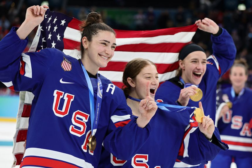 US players celebrate with their medals on the ice after the ceremony.